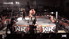 wrestlers in a ring with a sign that says wr