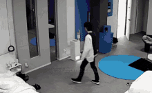 a man is walking in a room with the word neome zero on the bottom right corner .