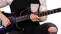 a man playing a purple electric guitar with a black shirt