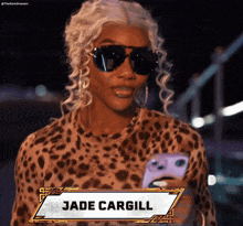a woman wearing sunglasses and a leopard print shirt has the name jade cargill on the front of her shirt