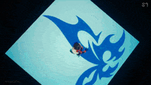 a person is laying on a blue surface with a s on the bottom right corner