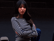 a woman wearing a striped shirt with the letter g on the front