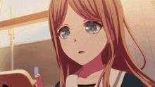 a girl with long hair and blue eyes is looking at a cell phone