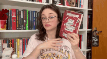 a girl holding a book that says box garota segredo mortal