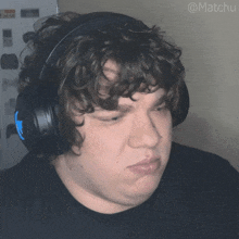a man with curly hair wearing headphones with the hashtag @matchu on the bottom