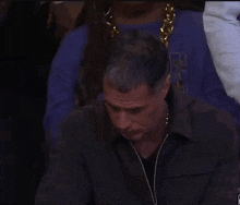 a man with a gold chain around his neck is wearing a purple shirt that says vegas