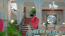 a woman in a red dress is walking up stairs