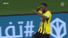 a man in a yellow shirt is dancing in front of an ad for spl.sa