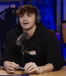 a man wearing headphones is sitting in front of a microphone that has the word prime on it