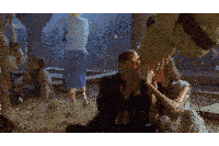 a man and a woman are sitting on the ground covering their faces with their hands
