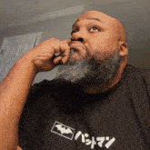 a bald man with a beard is wearing a black shirt that says batman