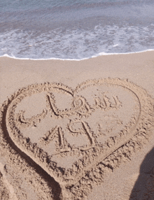 a heart drawn in the sand on a beach with the word love written in the middle