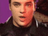 a close up of a man 's face with a red and purple background