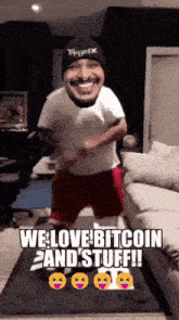 a man wearing a beanie and shorts is jumping in the air with the words we love bitcoin and stuff written below him
