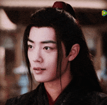 a close up of a young man 's face with long hair