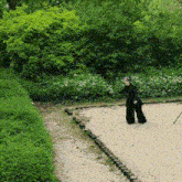 a person in black pants is standing on a sandy path