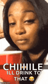 a woman is holding a red cup in her hand and making a face .