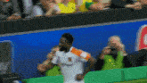 a soccer player in an orange and white jersey runs on the field