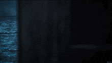 a dark room with a blue light coming out of the corner and a url written on the bottom right corner