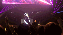 a crowd of people are watching a dj on stage