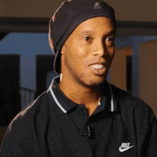 a man wearing a black nike shirt and a black beanie