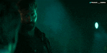 a man in a dark room with the words pranay varma on the bottom right