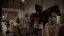 a man is riding a horse in a dark living room