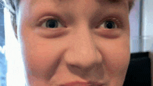 a close up of a person 's eyes with a slight smile on their face