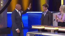 a man in a suit giving a high five to another man on a stage