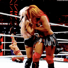 two women wrestling in a ring with a sign that says ' the next big thing ' in the background