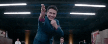 a man in a suit is dancing in front of a crowd .