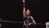 a woman with her arms outstretched is wearing a black top with sequins