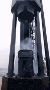 a large black object with a smoke coming out of it and the letters a and b on it