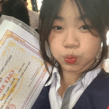 a girl is holding up a certificate that says " giấy chứng " on it
