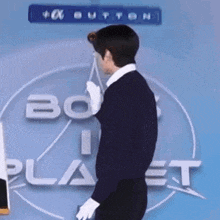 a man is standing in front of a sign that says ' bo planet ' on it .