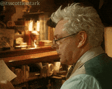 a man with white hair and glasses is reading a piece of paper with the hashtag @itsscottiesstark