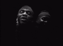 a black and white photo of two men wearing head bands