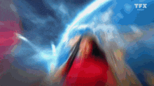 a blurry picture of a person standing in front of a blue planet with tfx inedit written on the bottom