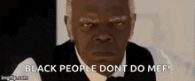 a man in a suit and bow tie is making a funny face and saying `` black people do n't do me ! ''