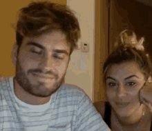a man and a woman are sitting next to each other and the woman is smiling .