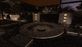 a dark room with a round table and a vase of flowers