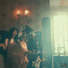 a woman in a pink dress is standing in front of a mirror with the letters ms below her