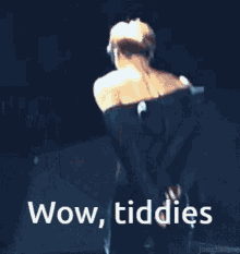 a shirtless man is dancing on a stage with the words wow tiddies written above him