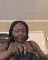 a woman in a black bra is holding a purse in her hands .