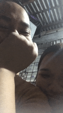 a man and a woman are looking at each other with a roof in the background