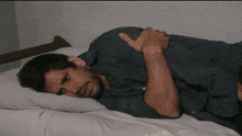 a man laying on a bed with his hands on his stomach