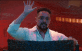 a man in a white shirt is making a funny face with his hands in the air