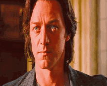 a man with long hair is looking at the camera