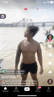 a man without a shirt is standing in front of a bridge