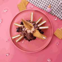 a pink plate topped with ice cream cones and sandwich cookies